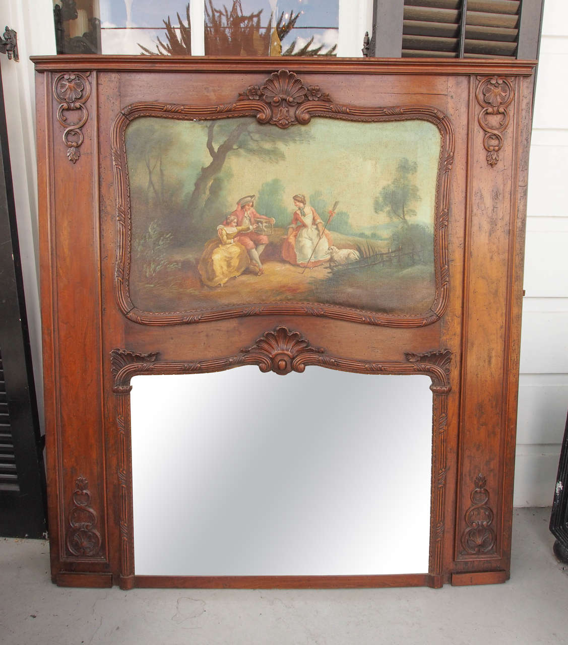 French Regence trumeau mirror of walnut with oil on canvas of French genre scene.