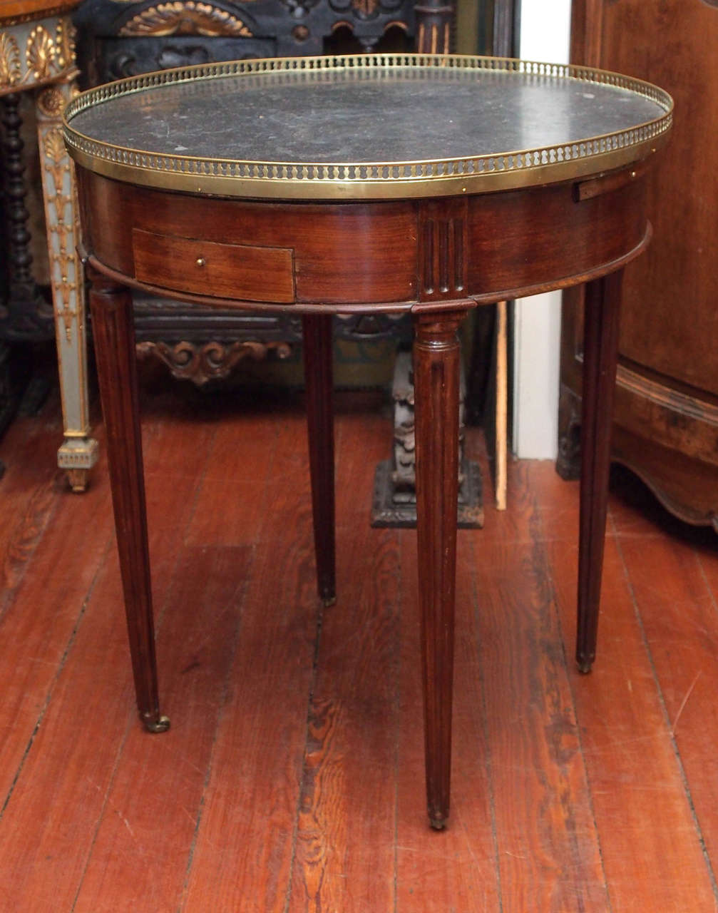 French Louis XVI Period Bouillotte Games Table with pierced brass rail, two candleholders and two drawers. Original bronze wheels