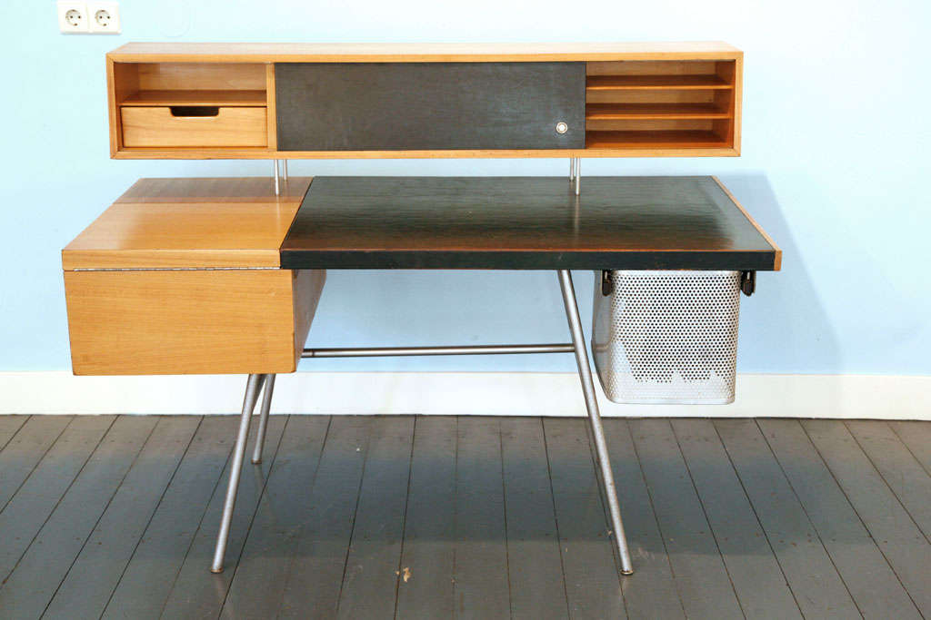 great desk featuring two drawers, two doors conceiling two drawers and five shelves and one flip-top compartment together with matching original chair with fabric from Alexander Girard.