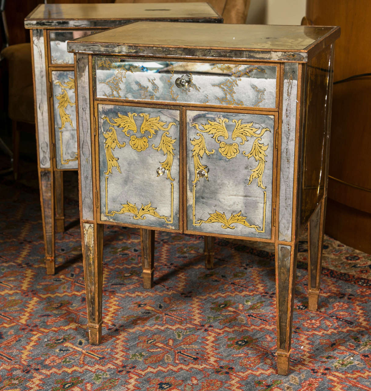 A fine Art Deco style distressed and gilded stand, circa 1940s, overall veneered with églomisé glass panels, decorated with glass sphere knobs, raised on squared tapering legs ending in pegged feet. Used in the HBO Series, Money.