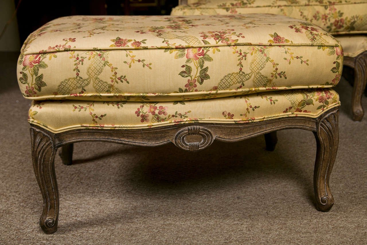 French Louis XV style Duchesse Brisee set by Jansen, circa 1940s, distressed and polychromed frame, upholstered in beige floral fabric, padded arms, cushioned seat, raised on cabriole legs. 

Ottoman measures 18.5 H by 29.5 Width by 21 Depth