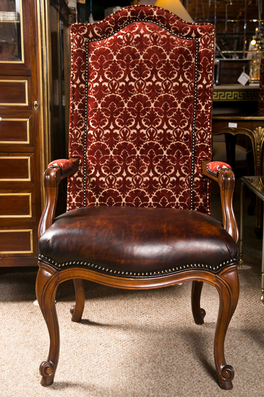 Set of 8 French Provincial style high-back dining chairs, the set consists of 2 armchairs and 6 side chairs, each has high, domed back, upholstered in red embroidered velvet decorated with nail heads, maroon leather seat, raised on carbiole legs