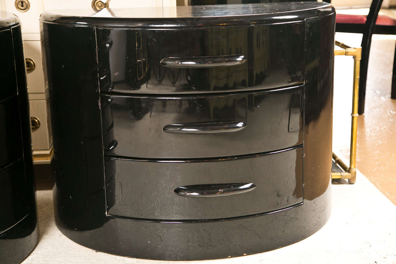 Pair of demilune chests of drawers in the Art Deco Atomic style, overall ebonized, each has three drawers.