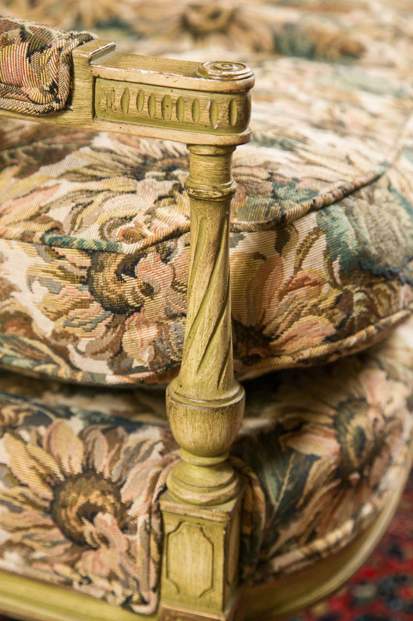 A lovely French Louis XVI style settee, circa 1940s, overall green/beige polychromed and parcel-gilt, the rectangular back decorated with finials and fluted spindle on each sides, extending to padded arms, cushioned seat, raised on tapering twisted