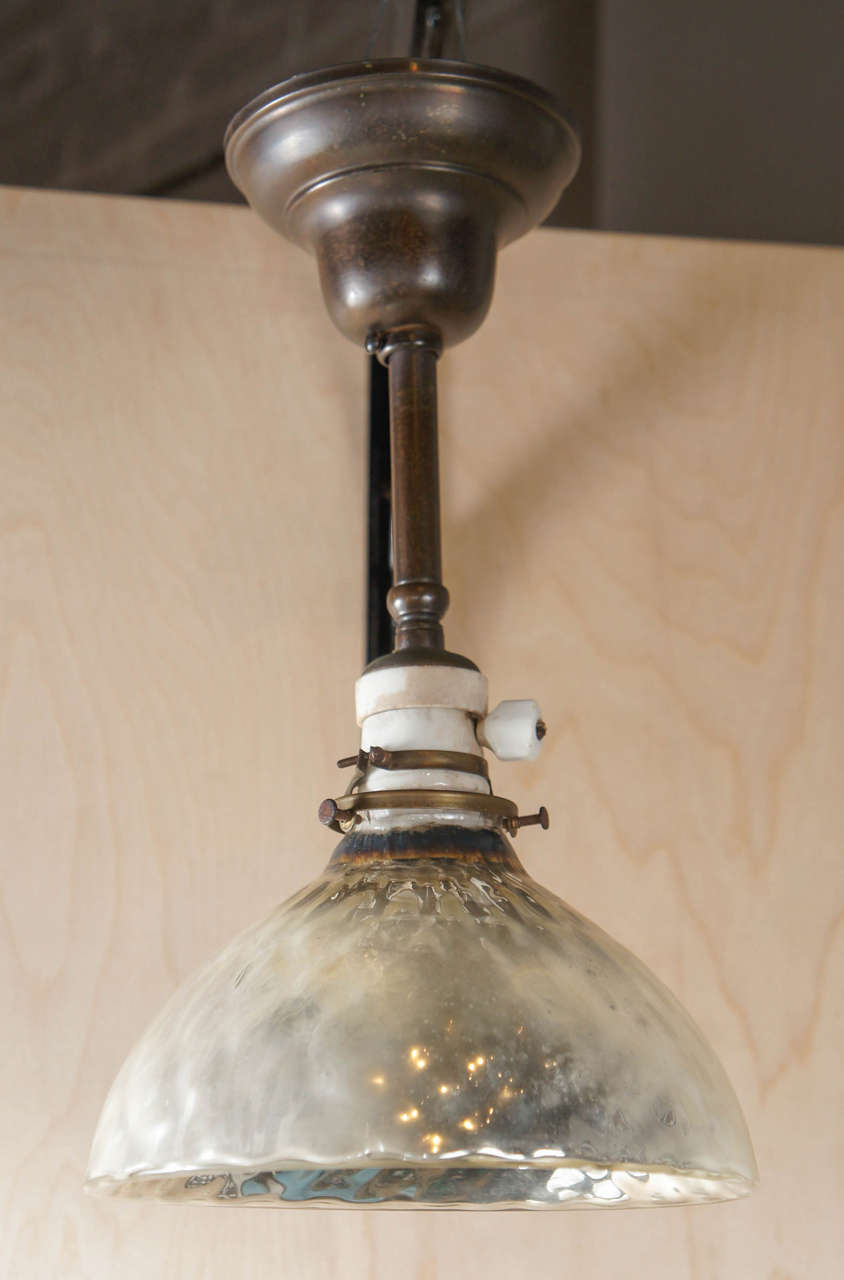 Set of 4 mercury glass pendant fixtures with original period porcelain socket and new brass patinated hardware.