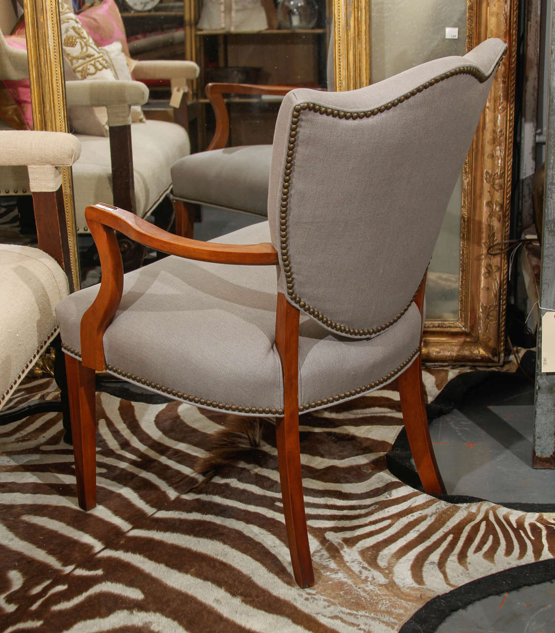 Shield back side chair in grey linen with nailhead trim.
