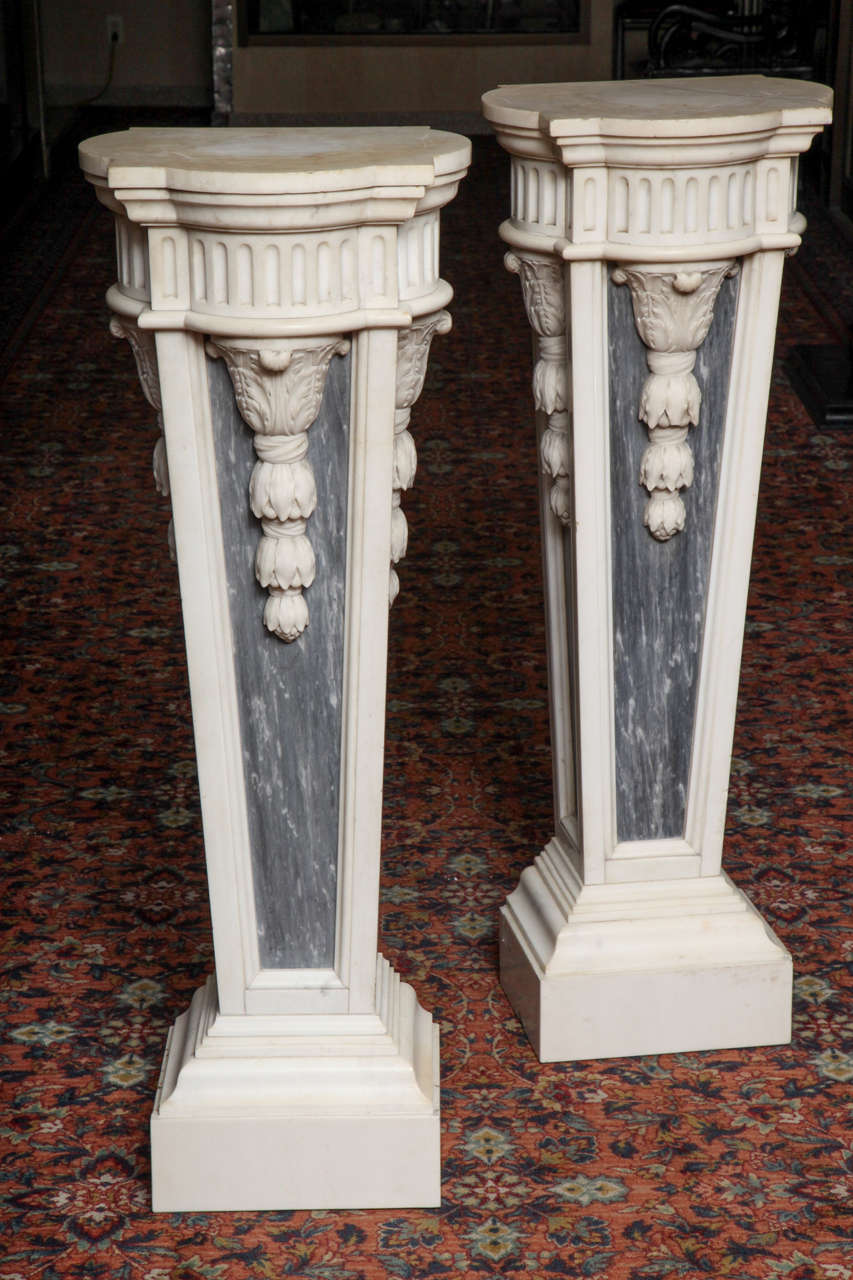 Neoklassizistisches Paar palastartiger antiker französischer Sockel im Stil Ludwigs XVI. aus weißem und grauem Carrera-Marmor, handgeschnitzt, ungewöhnliche Form, verziert mit erhabenen dreidimensionalen neoklassizistischen Motiven, um