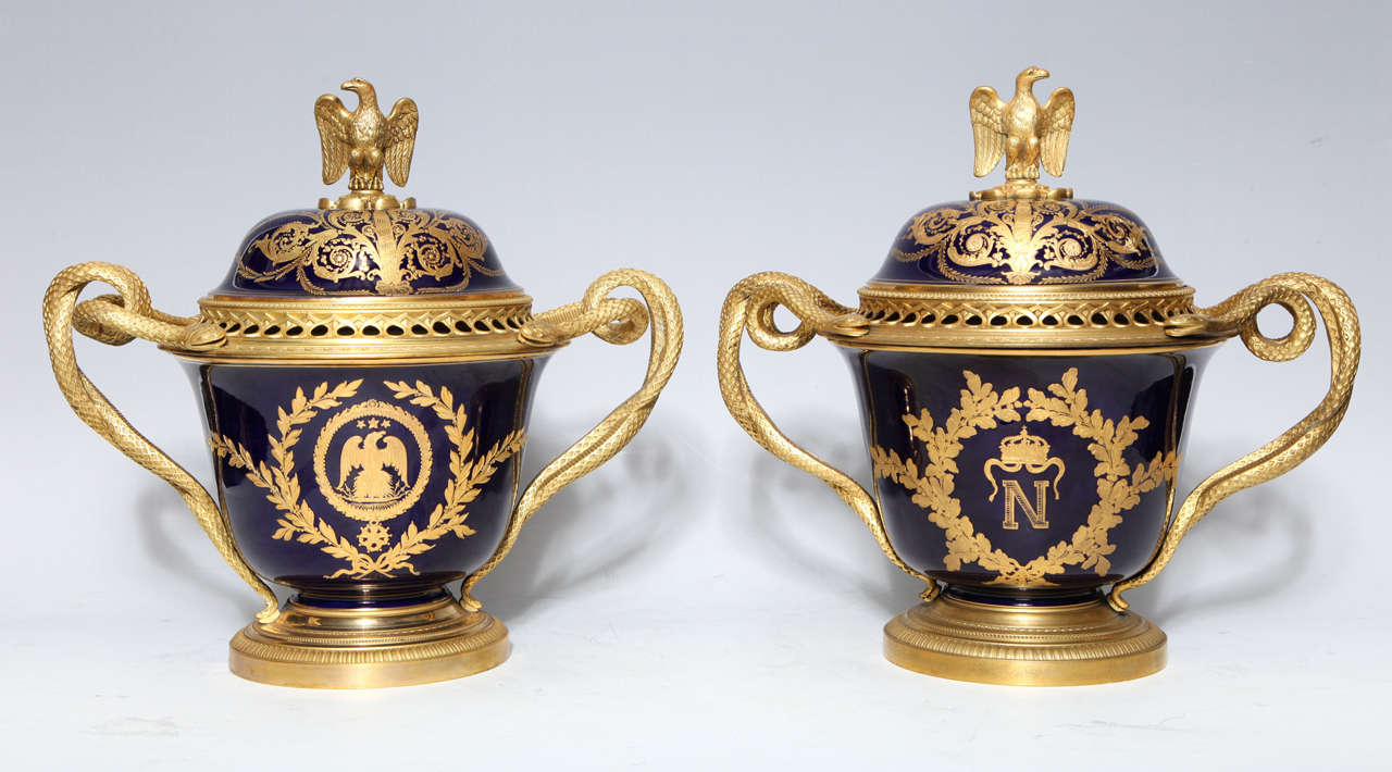 A pair of highly important and rare antique French Napoleonic gilt bronze mounted, cobalt blue, double handled, Royal Napoleonic Sèvres style porcelain covered vases/ pot pourries of exquisite craftsmanship. Embellished with hand painted raised gilt