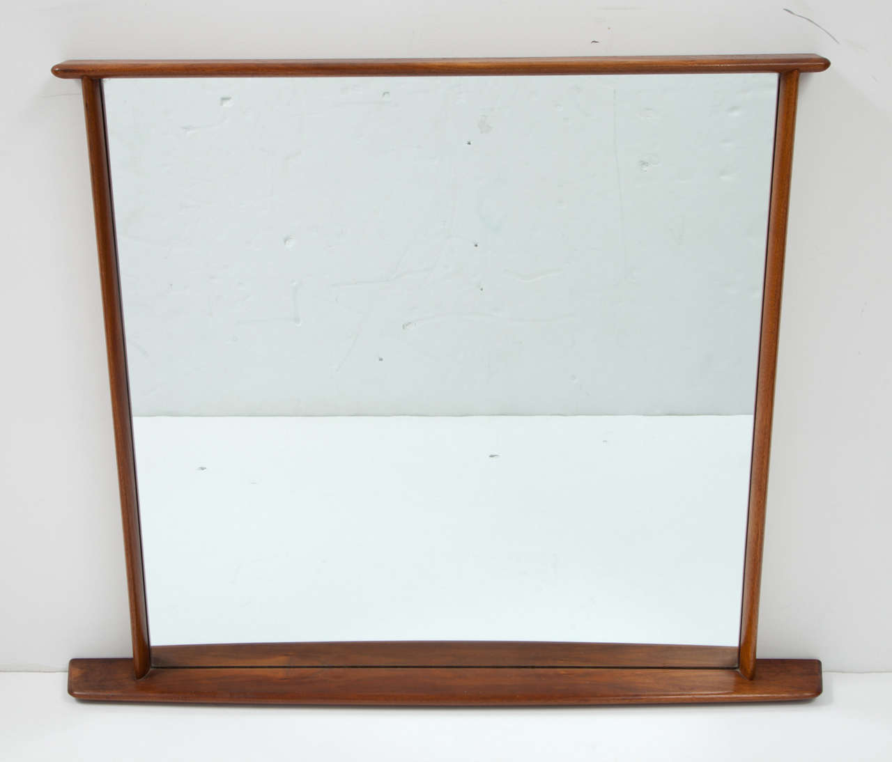 Walnut wall mirror, model 216-W,  with overhanging edge, made by Widdicomb.