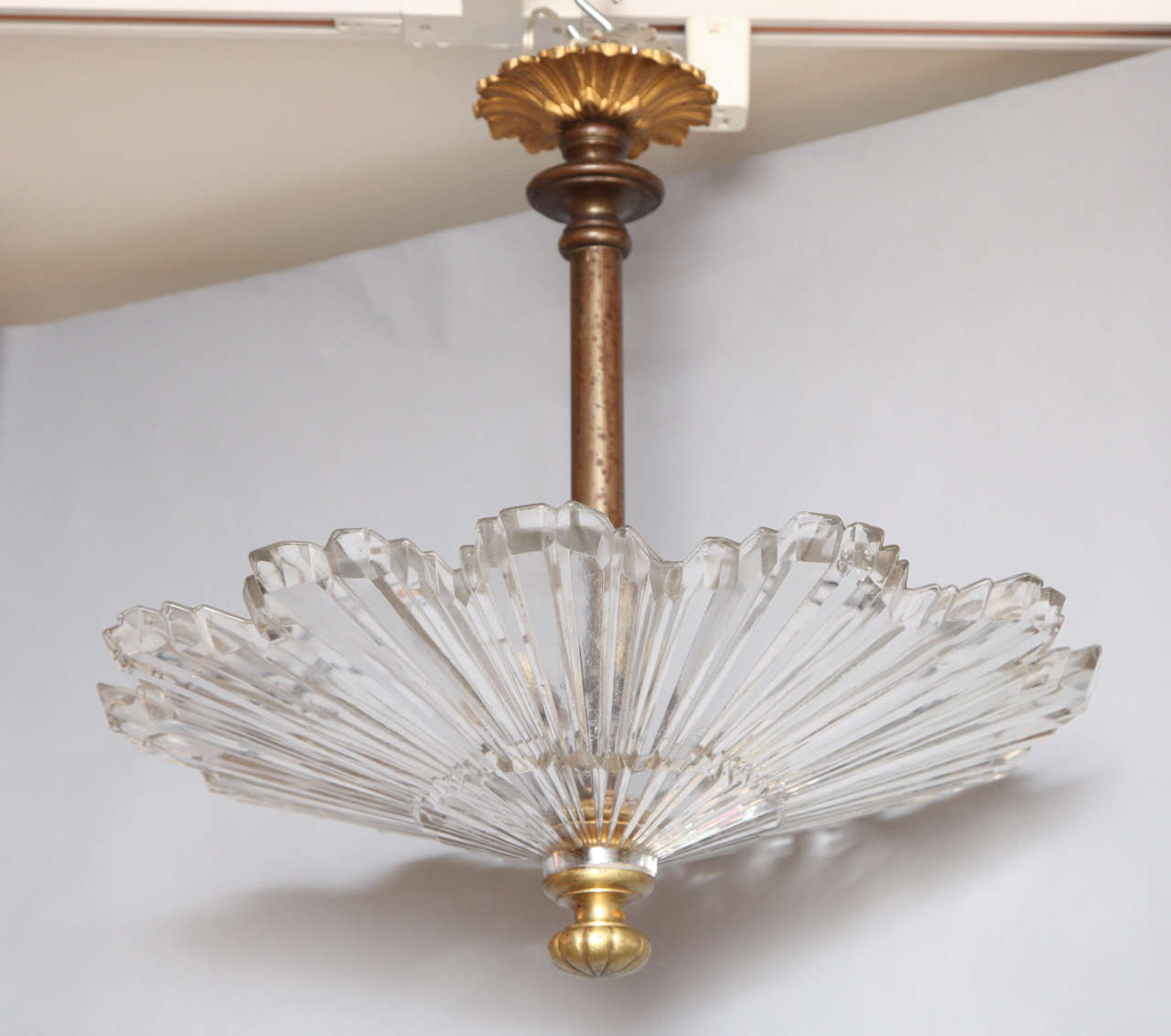 An American flush mount glass sunburst ceiling light with bronze rod, finial, and canopy.