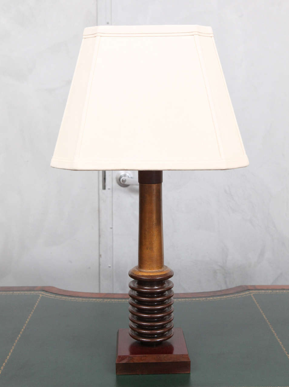 These are a beautiful table lamps made from glass electrical insulators painted with gold gilt and mounted on bakelite and wood layered bases with bakelite tops to the columns. The warm brown and gold tones of this pair of Folk Art lamps from the
