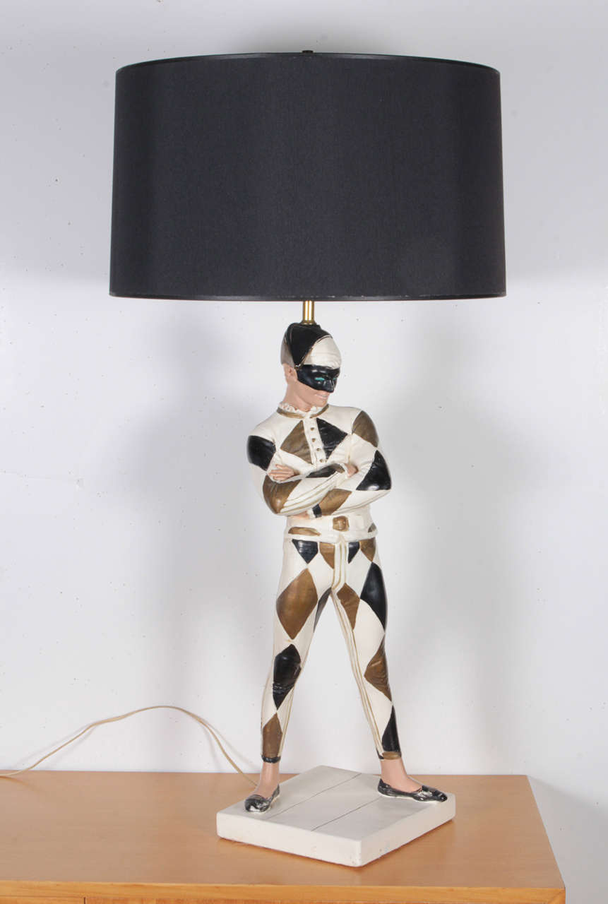 This large harlequin style table lamp features a mischievous, masked jester by Marbro. All Original. The body of the piece, including the figure, is composed of hand-painted plaster. Made in California, circa 1950s.