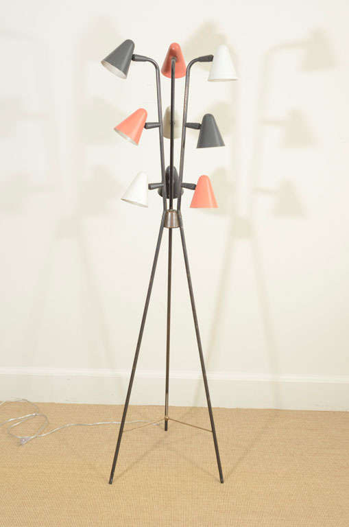 The black enameled tripod base supporting three sets of three colored enameled cone shaped shades.