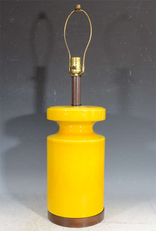 A pair of vintage cylinder form ceramic table lamps with a vibrant yellow glaze. Each sits on a wood base