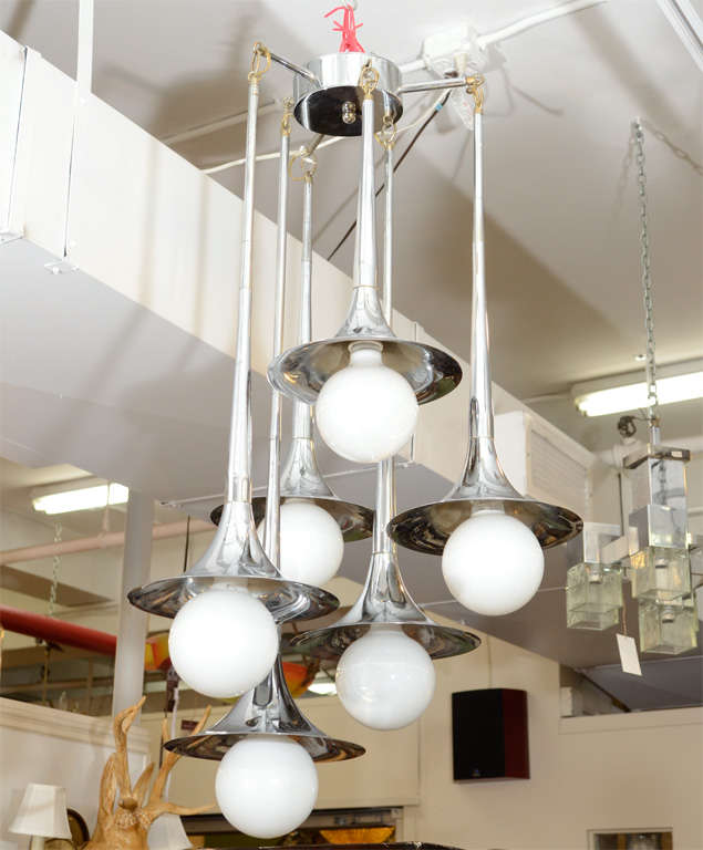 A vintage modernist Italian chandelier with six trumpet-shaped chrome light shades. The piece is by Reggiani.