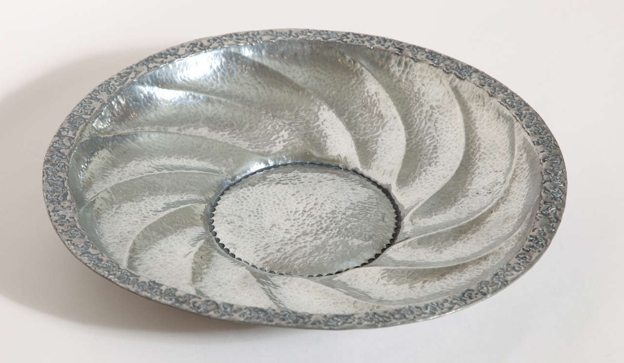 Hand-wrought dinanderie pewter tray with pinwheel design and applied metal to rim.
Signed: ''R. Delavan'' on body.
Stamped: ''R DELAVAN/ DECORATEUR/ PARIS/ ETAIN/ TRAVAIL AU MARTEAU'' underside.

Variety of other Rene Delavan pieces available.