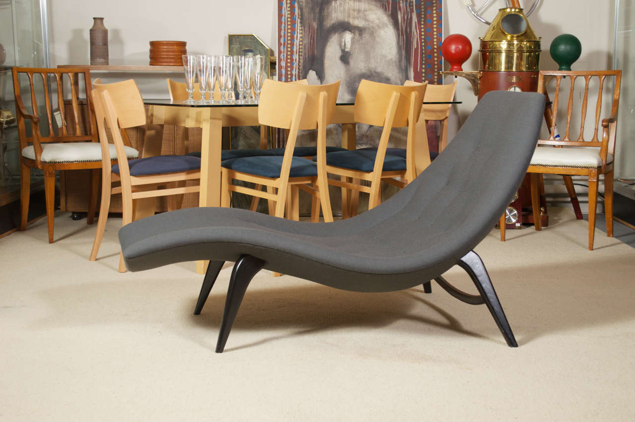 A curvy vintage 50's chaise lounge chair, refinished black legs and new upholstery that feels to be a poly blend. The designer is unknown, but it's very much in the style of Adrian Persall's work.