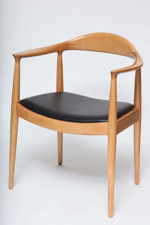 Hans J. Wegner 'The Chair' was manufactured by cabinetmaker Johannes Hansen and imported through Georg Jensen, Inc. for Chase Manhattan Bank. This chair is made of oak and has a black naugahyde slip seat.