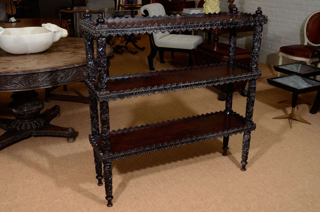 The etagere/bookshelf with three shelves and carved overall with floral and vine decoration.