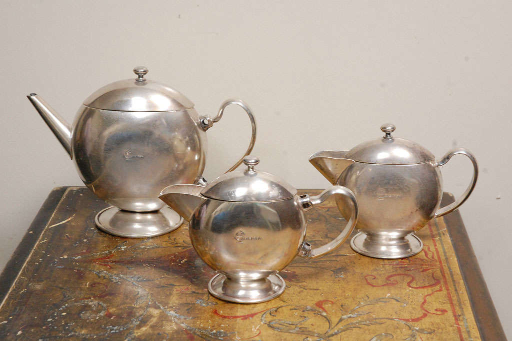 1930's vintage three piece silver plate coffee service with Chevron Logo. Manufactured by and stamped on bottom with Hacker, Sydney. 
Uncertain as to manufacturing location, either in Austria or Australia.
The largest pot measures 6 1/4