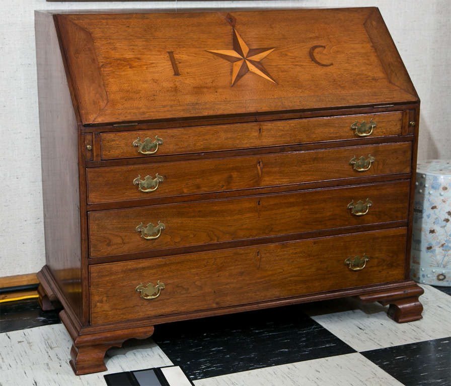 This walnut slant front bureau/desk of generous proportions is most likely American. It has an attractive interior with block front and serpentine drawers beneath pigeon holes, flanking two columnar slides and a central cupboard space beneath two