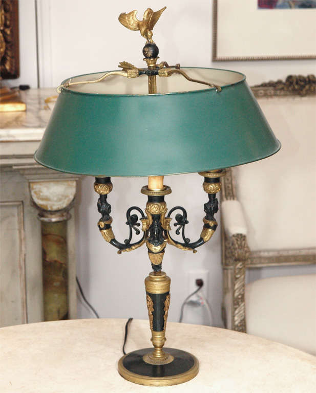 Magnificent French Neoclassical style three-arm bronze bouillotte lamp with exquisite neoclassical details. The candelabrum has faux candles with beeswax sleeves. The finial, an eagle with wings spread and perched on a ball, sits above a bronze