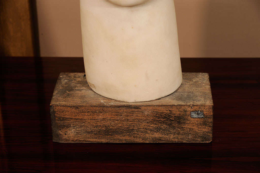The marble head created in the manner of Modigliani is mounted on a wood base. The work comes from a 1930s French sculpture studio.