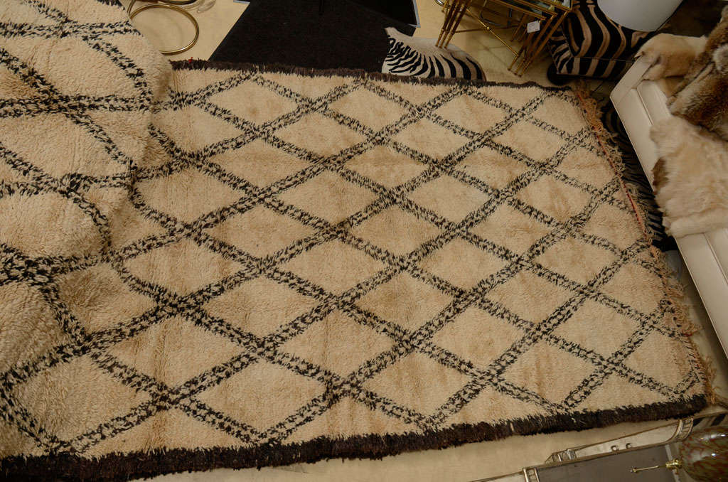 Beautiful and large Moroccan rug. It is hand-loomed, deep pile wool rug in an oatmeal color with a bold, geometric pattern. This one is SOLD. Please contact us for more rugs.