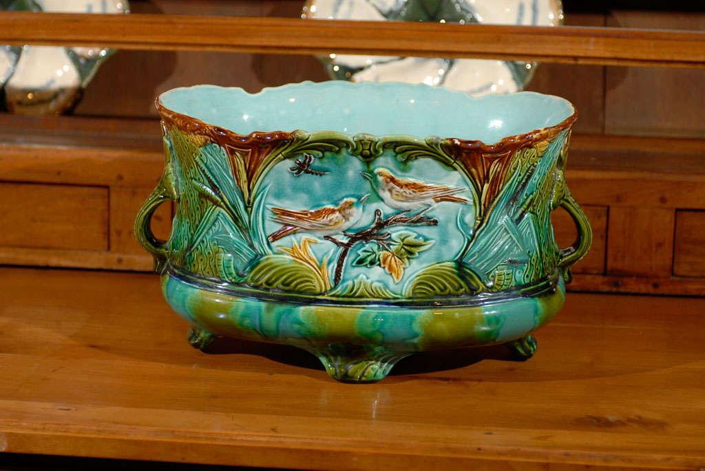 A French majolica cachepot from the early 20th century, with petite handles and feet, and  bird motifs. Born in France during the vibrant Roaring Twenties, this French majolica cache-pot features delicate turquoise, green and brown tones delicately