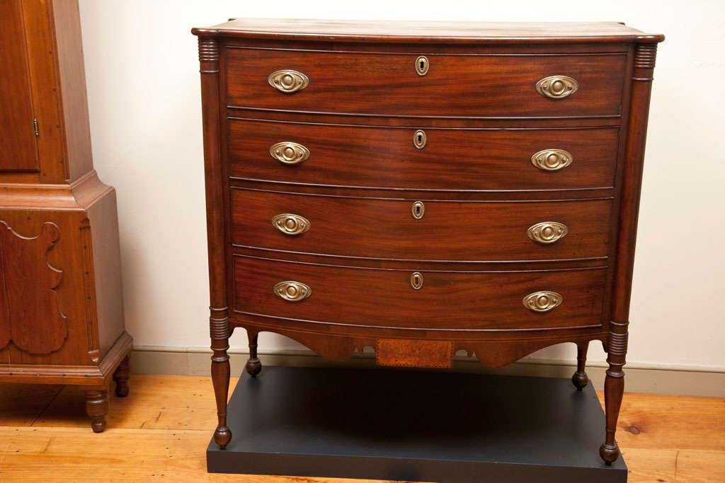 Spooner & Fitts Swelled-front Chest.<br />
A Sheraton Swelled-front Chest of Drawers in a fine old surface made by Spooner and Fitts, Athol, Massachusetts circa 1810. This chest has a rounded top with turret corners over a corresponding case of