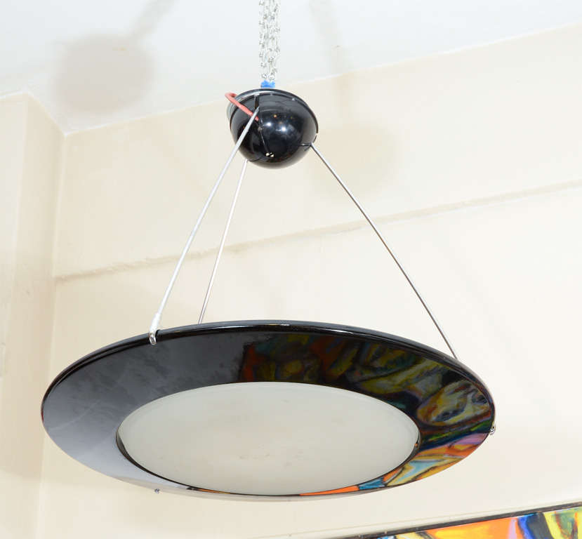 A mid century modern style hanging light with a round, frosted glass shade set into a glossy black-lacquered steel frame and suspended by three chrome bars from central ceiling mount.

Reduced From: $1200