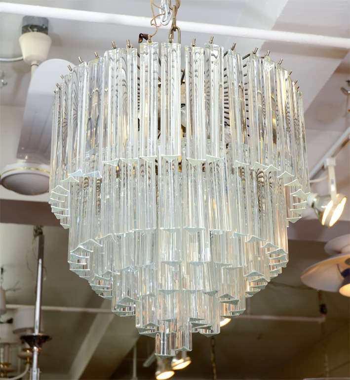 A vintage six-tier chandelier, produced circa 1970's in Italy, with faceted clear Murano glass triedri prisms, suspended from a metal frame. Good condition, with age appropriate wear.