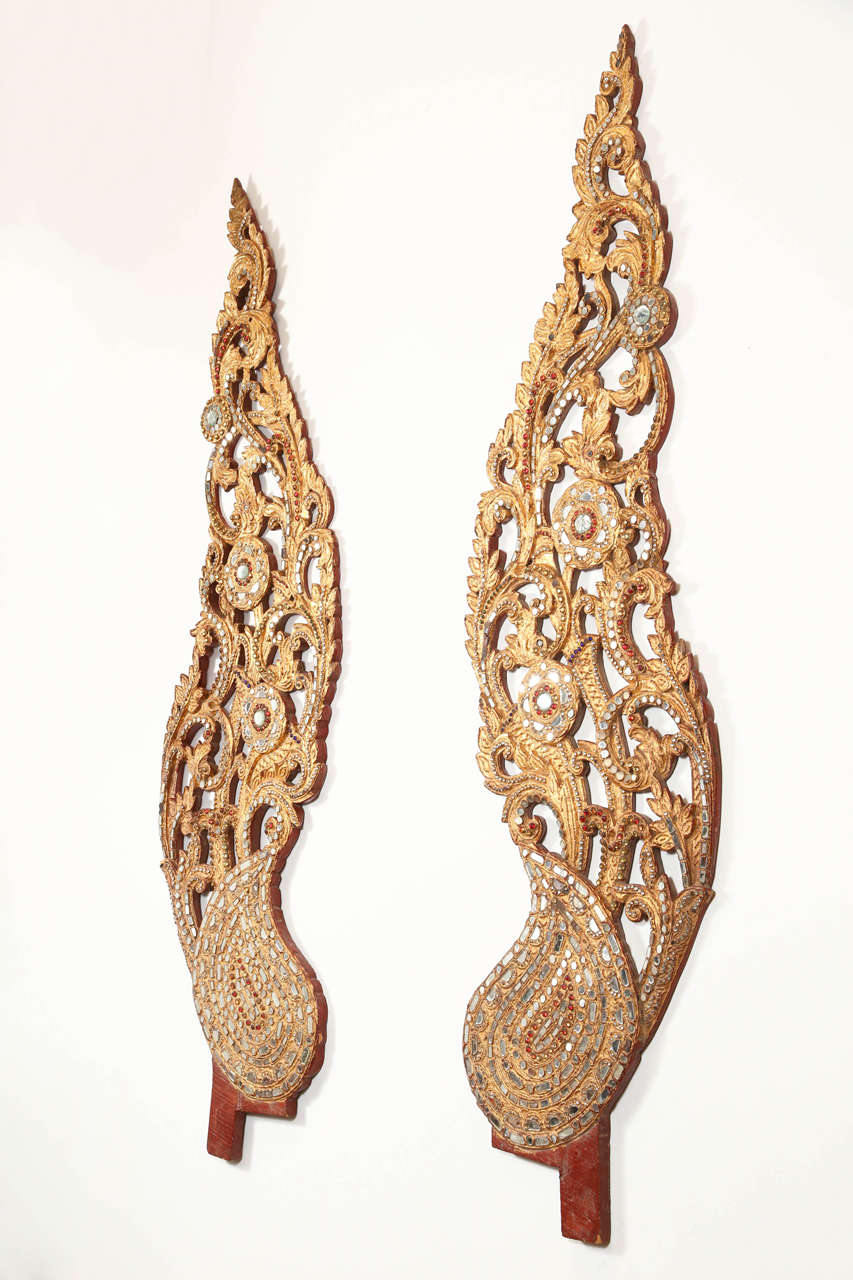 Pair of giltwood sculpture of wings, handcrafted in Thailand.<br />
Amazing handwork, giltwood adorned with small pieces of mirrors, delicate carving. Handmade of teak wood, gold leafed and rhinestones<br />
Wall-mounted architectural wooden sacred