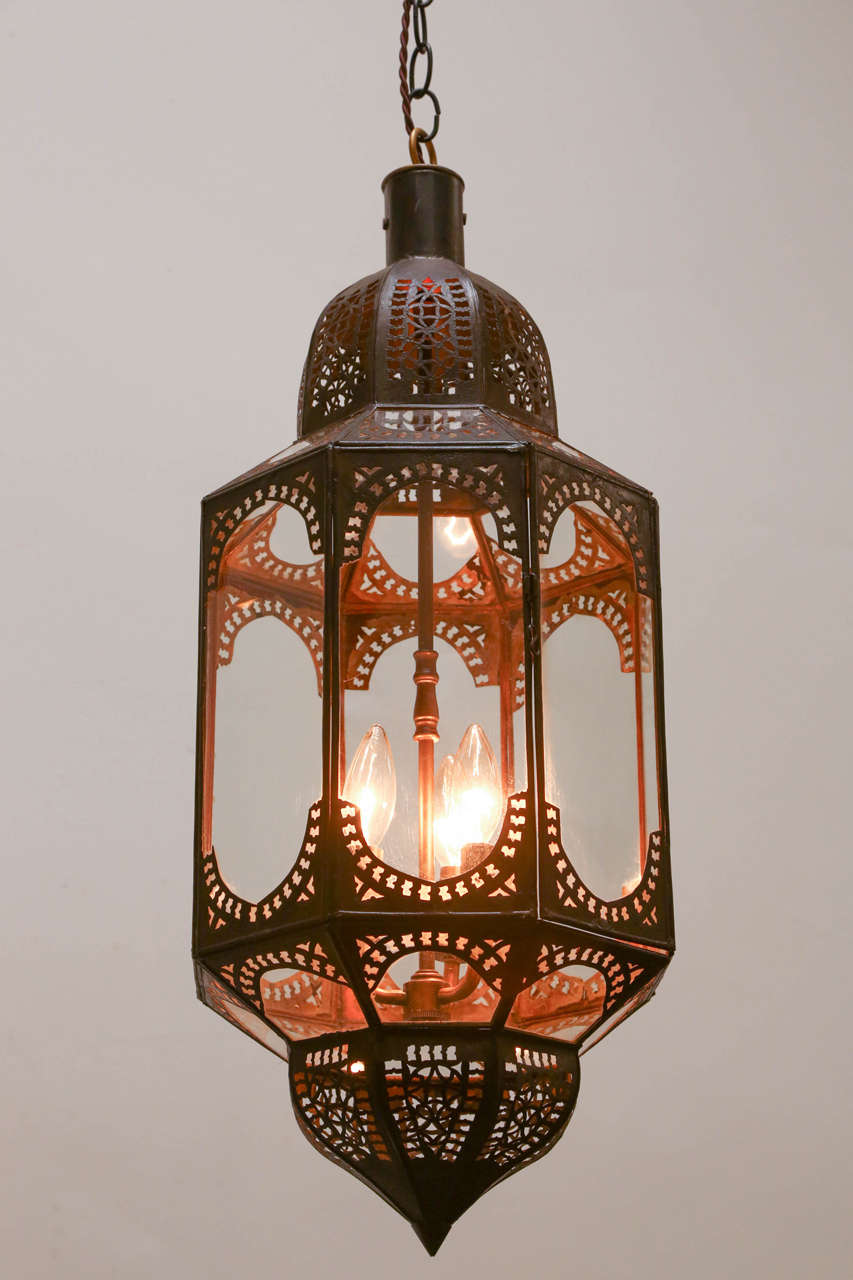 Elegant and Stylish clear glass handcrafted Moroccan lantern with intricate filigree work in the Moorish style. Will add elegance in any room. Rewired with three lights, ready to use, comes with three feet chains and ceiling canopy.<br />
We provide