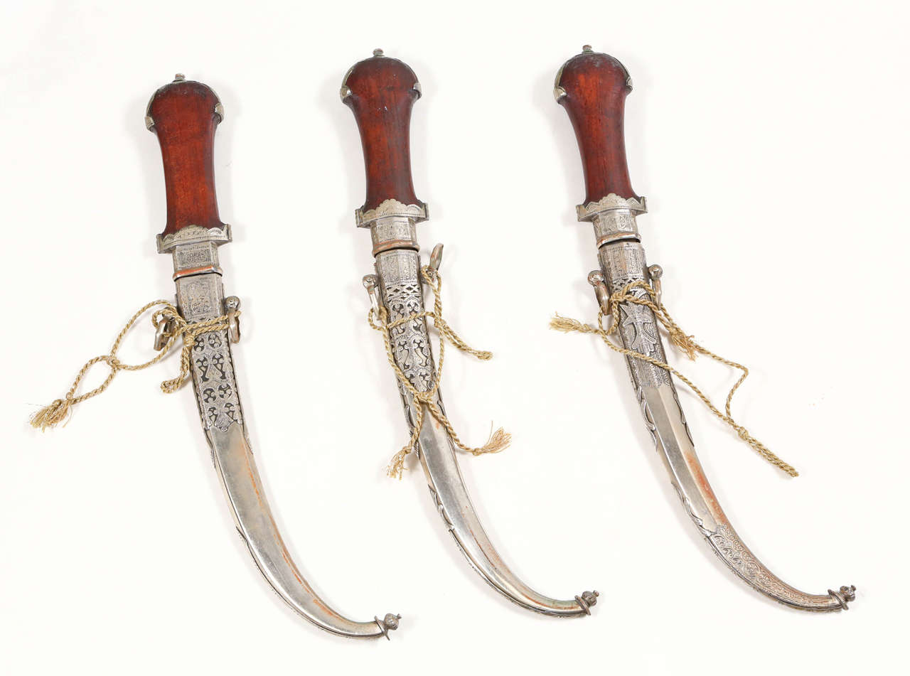 Set of three Moroccan Tribal Koummya Daggers.
Handcrafted by Artisans in Morocco, very fine quality craftsmanship with a wooden grip engraved with Moroccan silver and chiseled in scrolling foliage.
Double edge blade with maker marks.