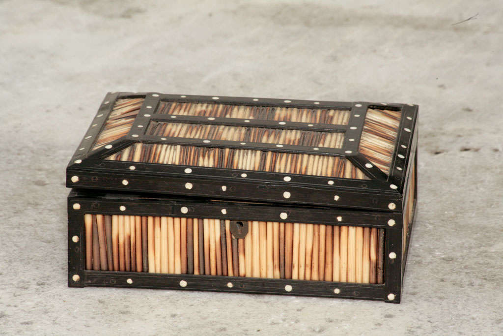 A Anglo-Indian Porcupine Quill box, with ebonized wood trim and mother-of-pearl decorations on the edges and in the interior of the box.
