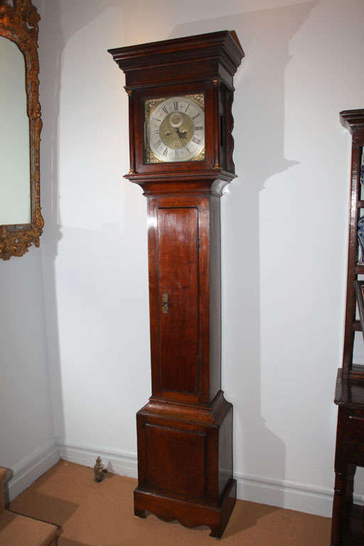 Fine 18th century English tallcase clock, the 8 day movement with brass face and silvered chapter ring by John Glover, London, the case of provincial manufacture in well-patinated oak, the square molded top over dentil and fluted moldings supported