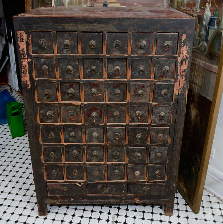 19th Century Chinese apothecary chest with 42 small drawers and 3 bottom drawers with metal pulls.  Front paper calligraphy details.