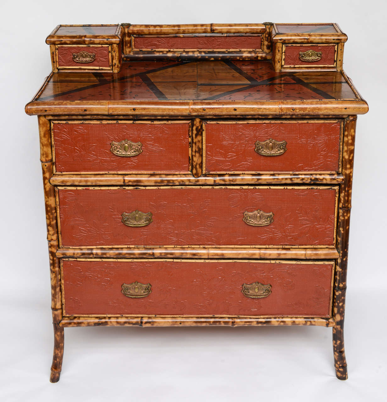 A late nineteenth English century bamboo chest of drawers in the Japanese taste having painted top over four drawers  with embossed paper decoration.