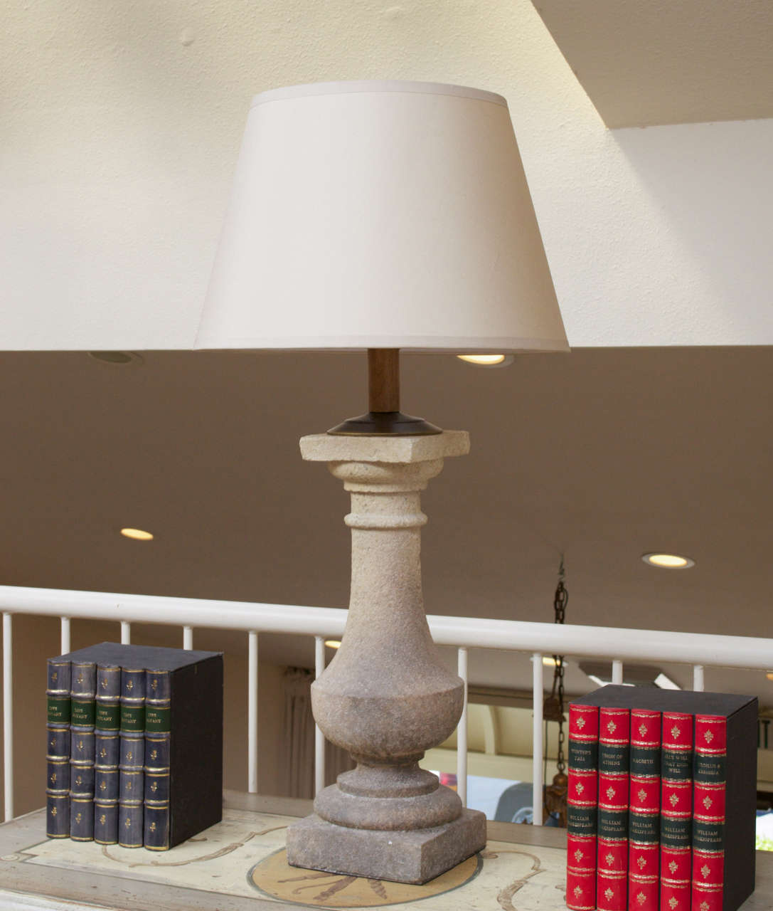 A pair of stone balustrade lamps with linen shades and wired for use