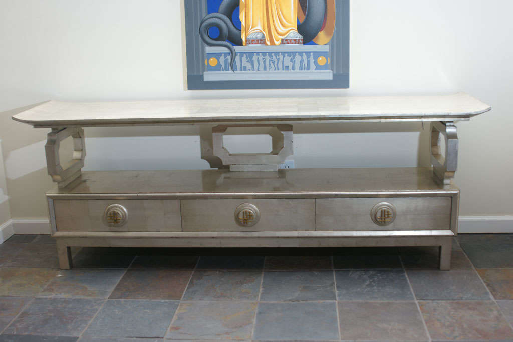 This beautiful silver leafed pagoda console by James Mont retains its original silver leaf finish which is in outstanding condition. The console has three cut-out decals which support the pagoda top and has three drawers, with the center one which