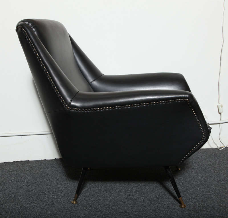 Single armchair designed by Gio Ponti, made in Italy in 1950, covered in the original black vinyl with black iron legs and brass feet. Beautiful form, authenticated in the Gio Ponti archives. 
