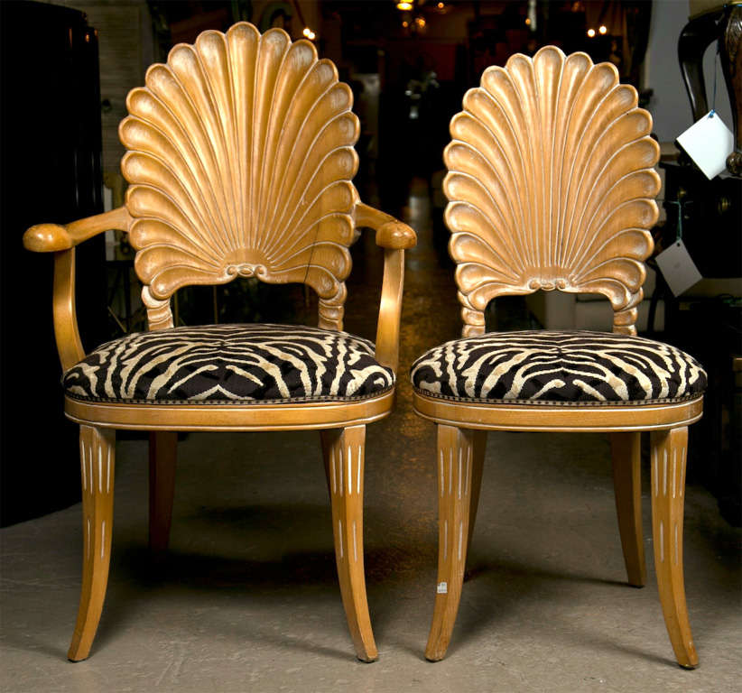 A set of twelve (ten side and a pair of arm) dining chairs. The curved and tapering legs leading to a leopard fabric set. The backs carved in the style of a shell. Nicely distressed finish. Can buy as many as you like. Arm Chair Dimensions 39 h,
