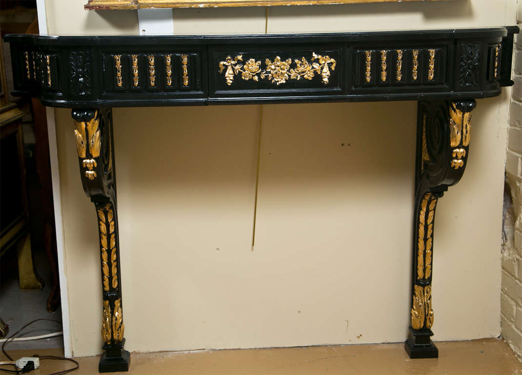 Ebonized and parcel-gilt wall-mount console table, the serpentine top over a fluted frieze fitted with a single drawer with oak secondaries, supported by wall-mounted pedestals.