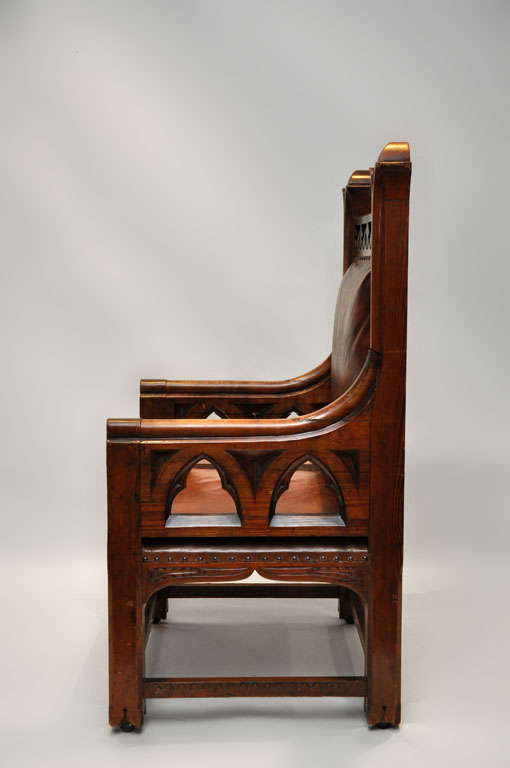 Rare gothic oak throne chair with leather upholstery, supported on four square legs connected with stretchers. Label underneath, Harding & Sons 161 162 Union St. Plymouth, England company founded in 1858.