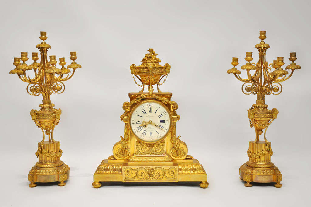 An extraordinary French Louis XVI style gilt bronze mantle clock, enamel white dial with roman numeral numbers and gilt pierced hands inscribed Lepine Aarie Place de Victoires 2.   Dial surmounted with a classical covered urn adorned with beaded