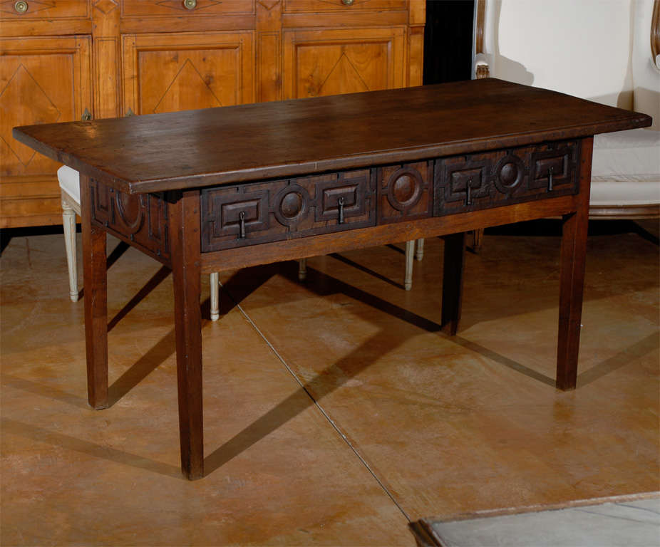 A Spanish early 17th century wooden console table with two drawers and geometric carving. Born in the early 1600s, this Spanish table features a rectangular top sitting above an exquisitely carved apron with very fine geometric carving. This apron