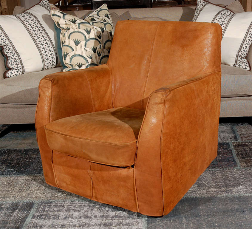 A club chair of full proportions on low feet in a custom suede slip cover
