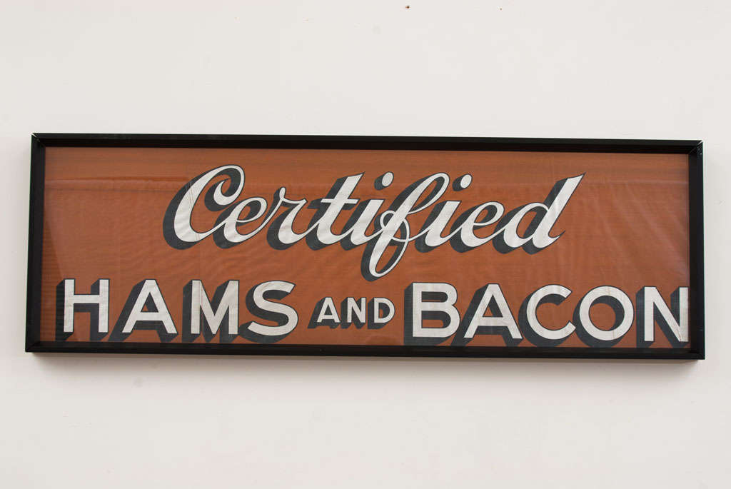 This sign advertising Hams and Bacon has great color and contrast!  Warm tobacco-brown background with silver letters and black shadowing.  Rare chromolithograph sign on canvas...not paper.  Black metal frame.  I have a history of the Meyerchord