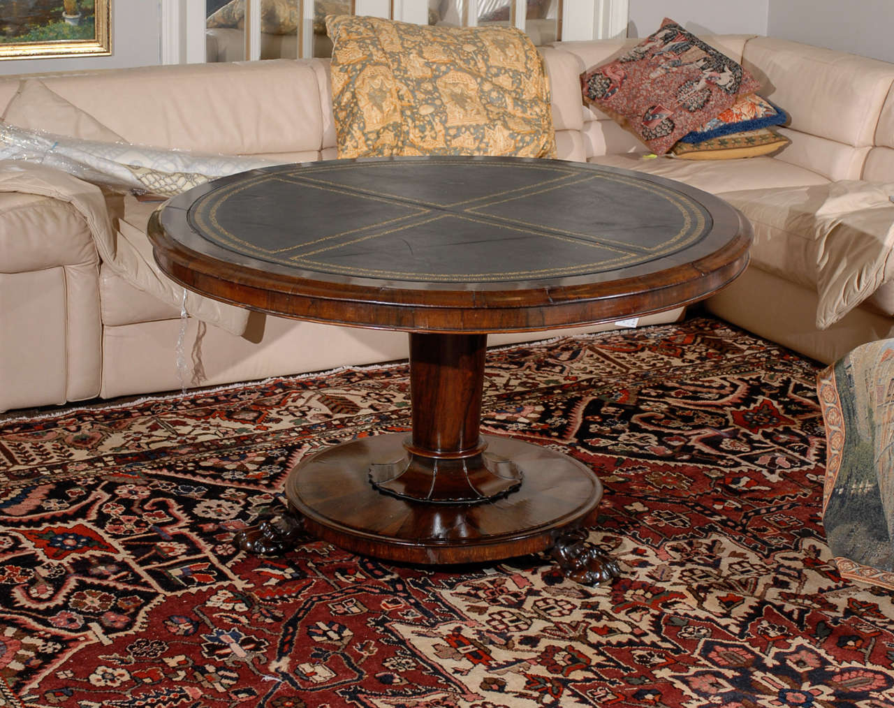 William IV rosewood tilt-top centre table with circular leather-inset top within molded edge and skirt on columnar pedestal with circular base upon carved paw feet.